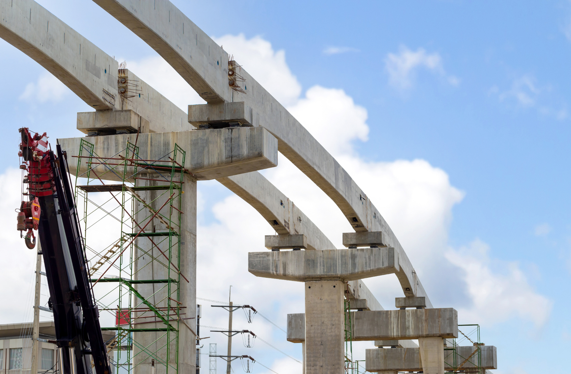Large-scale civil infrastructure project featuring concrete railway elevated supports and crane scaffolding.