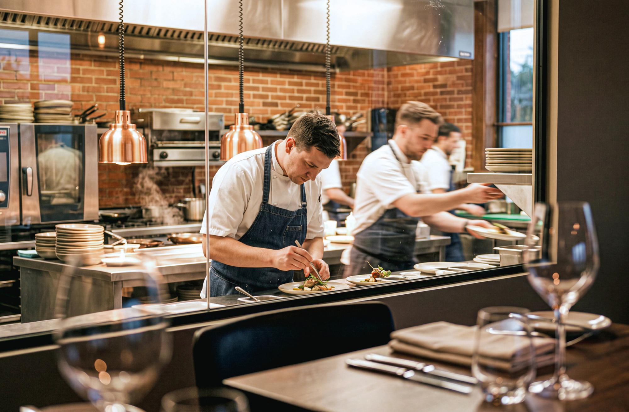 Restaurant waitstaff setting a dining table for peak trading service supported by hospitality visa sponsorship in Australia